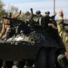 Des soldats ukrainiens sur un véhicule blindé de transport de troupes sur une route de la région de Donetsk.