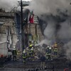 Des pompiers et des secouristes près d’un bâtiment touché par un missile dans le centre de Kiev, le 23 novembre 2022 à Kiev.