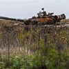 Un char d'assaut russe brûlé dans un champ de tournesols.