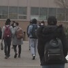 Des étudiants marchent vers l'entrée d'un édifice du campus.