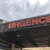 Du lettrage rouge attire l'attention sur l'entrée de l'urgence d'un hôpital. 