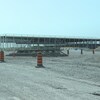 Une structure métalique est en cours de construction sur un chantier désert.