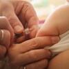 Gros plan sur un pédiatre qui vaccine un bébé.