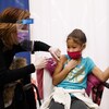 Isabella Martin, 8 ans, tient la main de sa mère pendant qu'elle se fait vacciner contre la COVID-19.