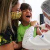 Le jeune brésilien Leonardo Larussi crie dans les bras de sa mère en recevant une dose du vaccin Pfizer.
