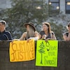 Quatre manifestants de la marche pour le climat tiennent des pancartes, à Vancouver, le 15 septembre 2023. 