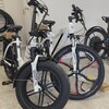 Des vélos électriques en salle d'exposition, dont un modèle à pneus surdimensionnés et un modèle de ville.
