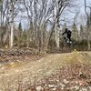 Un amateur de vélo de montagne est dans les airs au-dessus d'une piste.