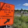 Une pancarte indiquant aux cyclistes d'attendre une navette dans un secteur où des travaux ont lieu.