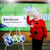 Vera Page pose à côté d'un grand chèque de Lotto Max.