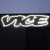 Le logo de Vice affiché sur la façade d'un immeuble noir, devant un ciel bleuté.