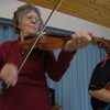 Une femme âgée joue du violon.