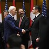 Le président américain Joe Biden serre la main du chef du Parti conservateur du Canada Pierre Poilievre, sous le regard du Premier ministre Justin Trudeau, lors d'une cérémonie de bienvenue sur la colline du Parlement à Ottawa, le vendredi 24 mars 2023.