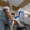 Un infirmier pousse délicatement une civière dans un couloir d'hôpital.