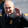 Vladimir Poutine salue de la main gauche. 
