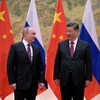 Vladimir Poutine et Xi Jinping devant des drapeaux russes et chinois.