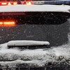 Une voiture de la Sûreté du Québec est stationnée. Les gyrophares fonctionnent.