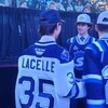 Un jeune joueur parle avec d'autres joueurs de hockey.