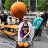 Une personne portant un chandail des Lakers lance des ballons de basketball.