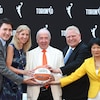 Des dignitaires tiennent ensemble un ballon de basketball.