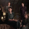 Huit femmes mennonites installées dans une grange regardent vers leur droite, dans une scène du film Women Talking. 
