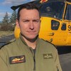 Le pilote en uniforme se tient devant l'hélicoptère de transport de troupes.