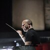 Yannick Nézet-Séguin tenant une baguette de chef d'orchestre dans une salle de répétition.