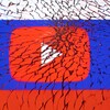 Le logo de YouTube, placé sur un drapeau russe, vu à travers une vitre brisée. 