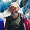 Robert Daffe sourit à la caméra, un glacier en arrière-plan.