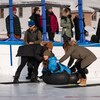 Trois personnes s'apprêtent à prendre part à la compétition de curling humain à Dawson, le 18 mars 2023. 