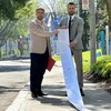 Sol Zanetti et le candidat solidaire dans Jean-Talon Olivier Bolduc sont sur le trottoir et montrent un gros document imprimé.