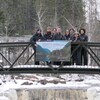 Des personnes sont debout sur un pont piétonnier en hiver.
