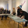Artistes dessinant sur des tables.
