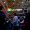 Le logo de Microsoft brille au milieu d'une foule de passants.