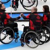 Trois joueurs de curling en fauteuil roulant se félicitent lors d'une partie.