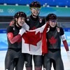 Valérie Maltais, Isabelle Weidemann et Ivanie Blondin posent avec le drapeau canadien après la course pour la médaille d'or. 