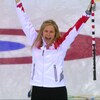 Jennifer Jones lève les bras et crie après une victoire.