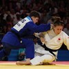 Une judoka est renversée par une adversaire.