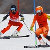 Le skieur guide Julien petit freine devant Logan Leach qui freine lui aussi entourés de portes.