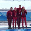 Le quatuor canadien se donne l'accolade en plus de poser pour la photo sur le podium en arborant fièrement leur médaille de bronze au cou. 