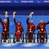 Les cinq membres de l'équipe canadienne de curling en fauteuil roulant souriants avec leur médaille.