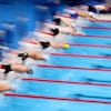 Des nageurs se lancent dans la piscine au début d'une épreuve des Jeux olympiques. On ne les distingue pas vraiment, ils sont flous. 