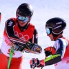 Le Canadien Trevor Philp est félicité par les membres de son équipe après sa descente de ski alpin à l'épreuve par équipe mixte.