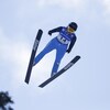 Une athlète effectue un saut à ski.