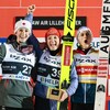 Alexandria Loutitt, à gauche, avec un manteau vert-de-gris et un bandeau blanc avec une feuille d'érable rouge bien centrée, célèbre sa deuxième place, skis blancs à la main, aux côtés de l'Allemande Katharina Althaus et l'Autrichienne Eva Pinkelnig.  