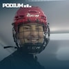 Gros plan d'une hockeyeuse qui sourit sous son casque rouge