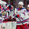 Un hockeyeur reçoit les applaudissements de ses coéquipiers au banc des Rangers de New York.
