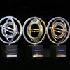 Trois trophées côte à côte sur fond noir