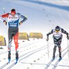 Deux skieurs tentent de prendre de la vitesse dans le sprint finale d'une course.