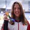 Elle sourit, médaille d'or en main.